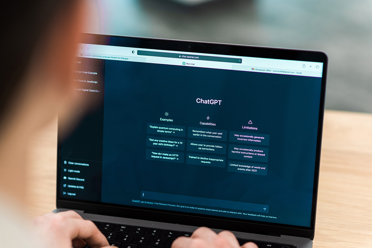 Person using a laptop with ChatGPT site on display.